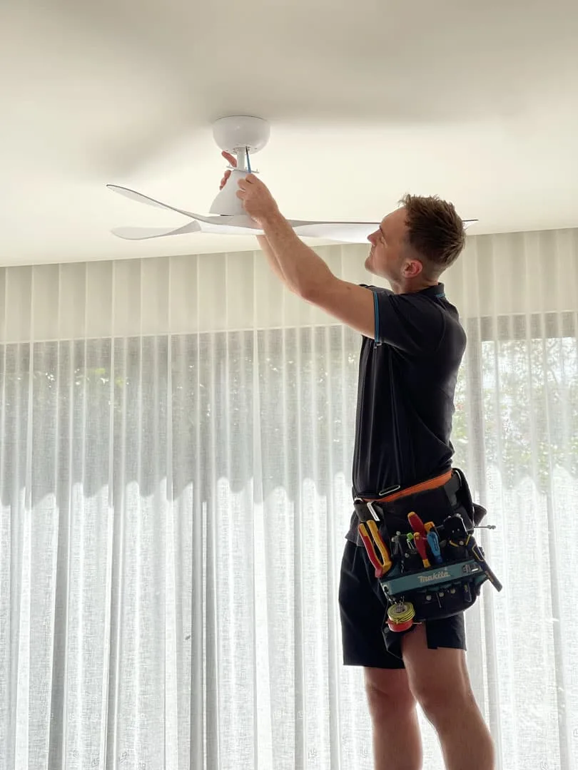 Electrician installing a ceiling fan
