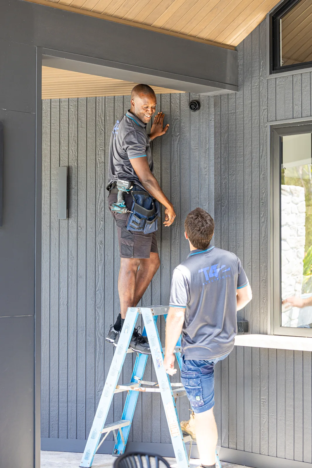Electricians installing an outdoor security camera