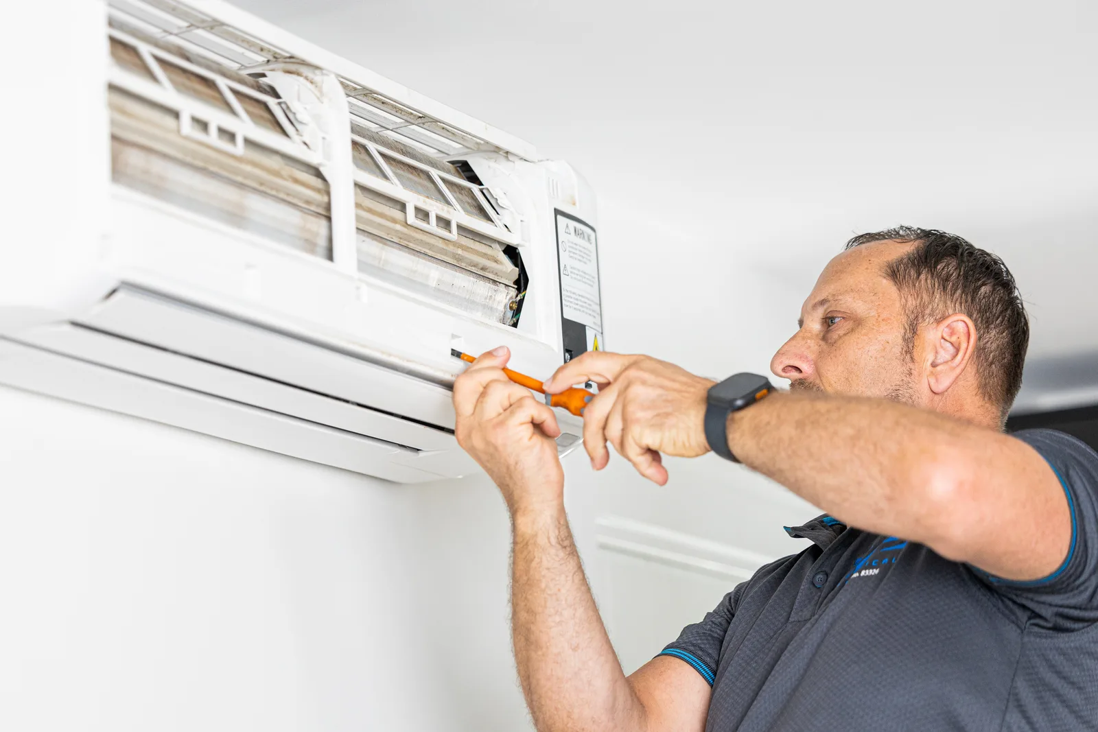 Technician servicing a wall-mounted unit